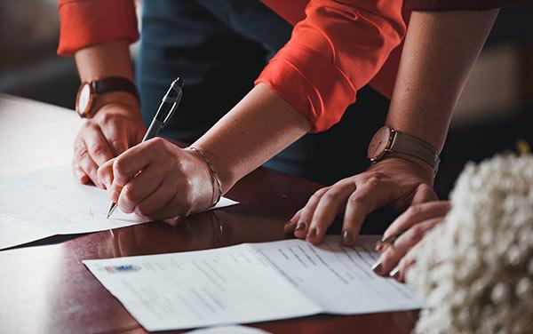 two people signing papers